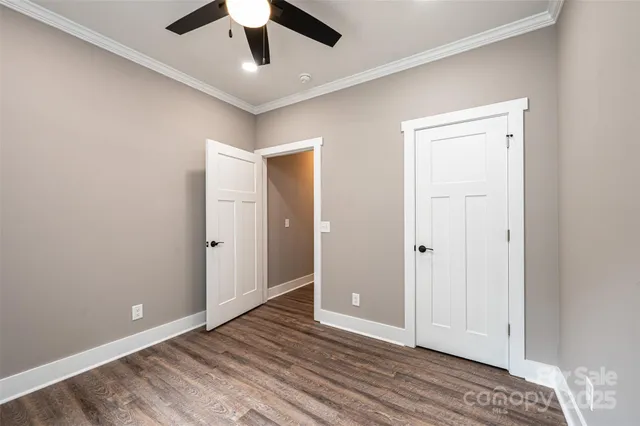 an empty room with windows and ceiling fan