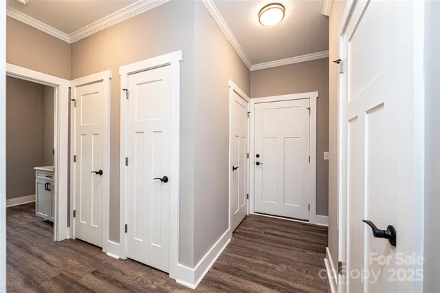a view of a hallway with wooden floor and closet area