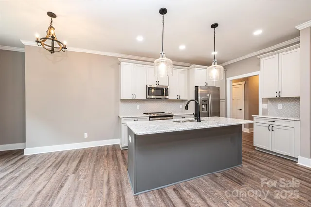 a kitchen with kitchen island a sink stainless steel appliances and cabinets