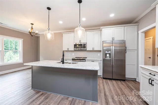 a kitchen with stainless steel appliances granite countertop a refrigerator a sink and a stove