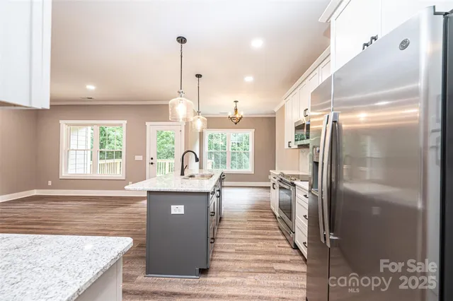 a kitchen with stainless steel appliances granite countertop a refrigerator and a sink