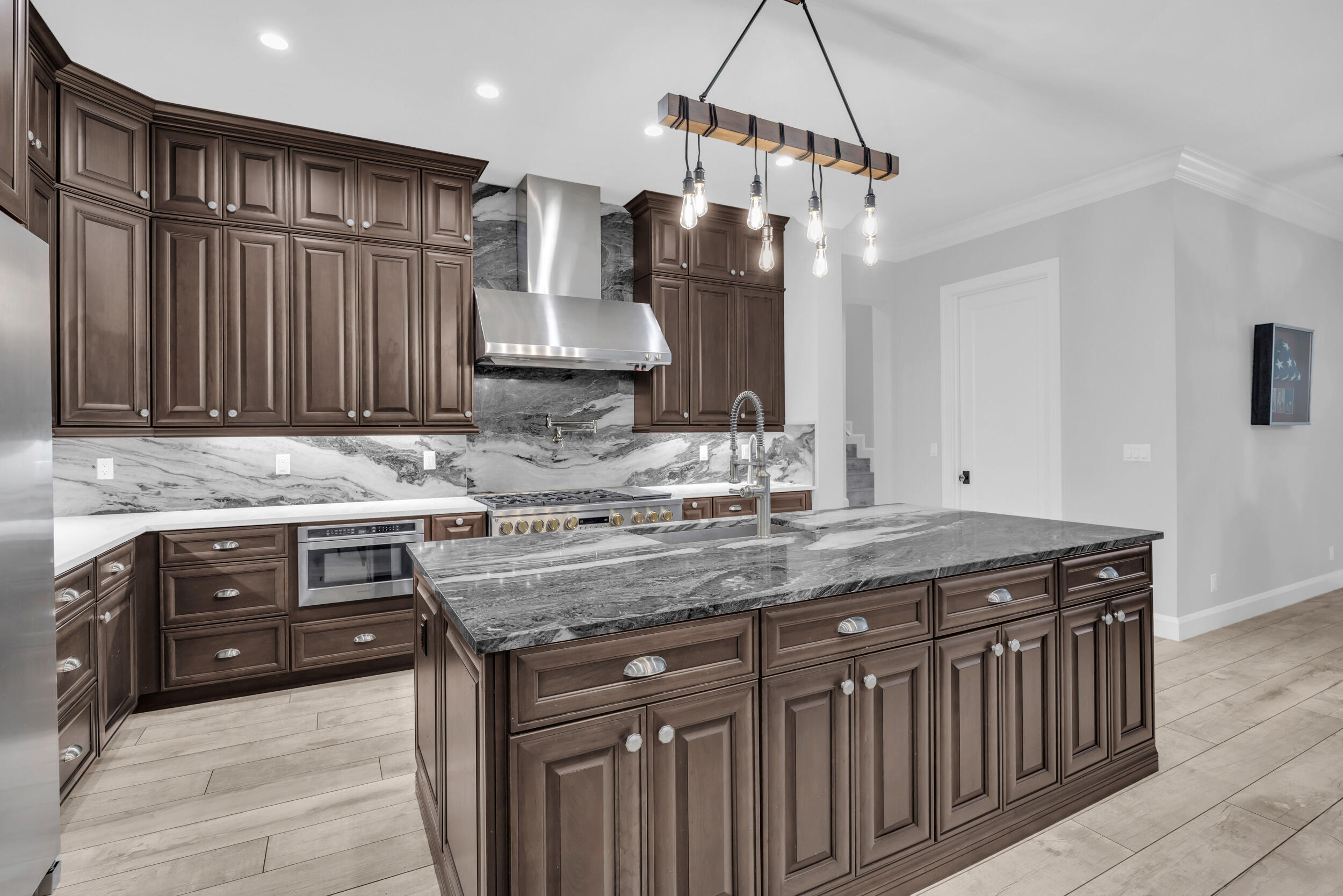 5481 Hibiscus Road Jupiter, FL 33458 - Photo 13 of 66 a kitchen with stainless steel appliances granite countertop a sink a stove and a wooden cabinets