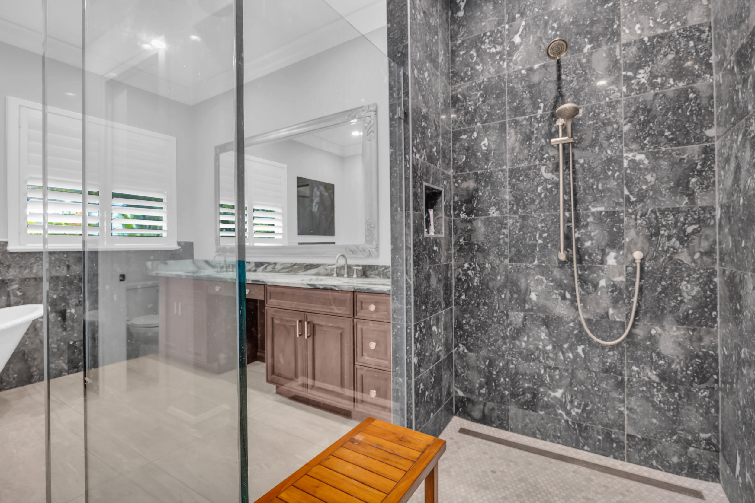 5481 Hibiscus Road Jupiter, FL 33458 - Photo 27 of 66 a bathroom with a granite countertop sink a mirror and a shower