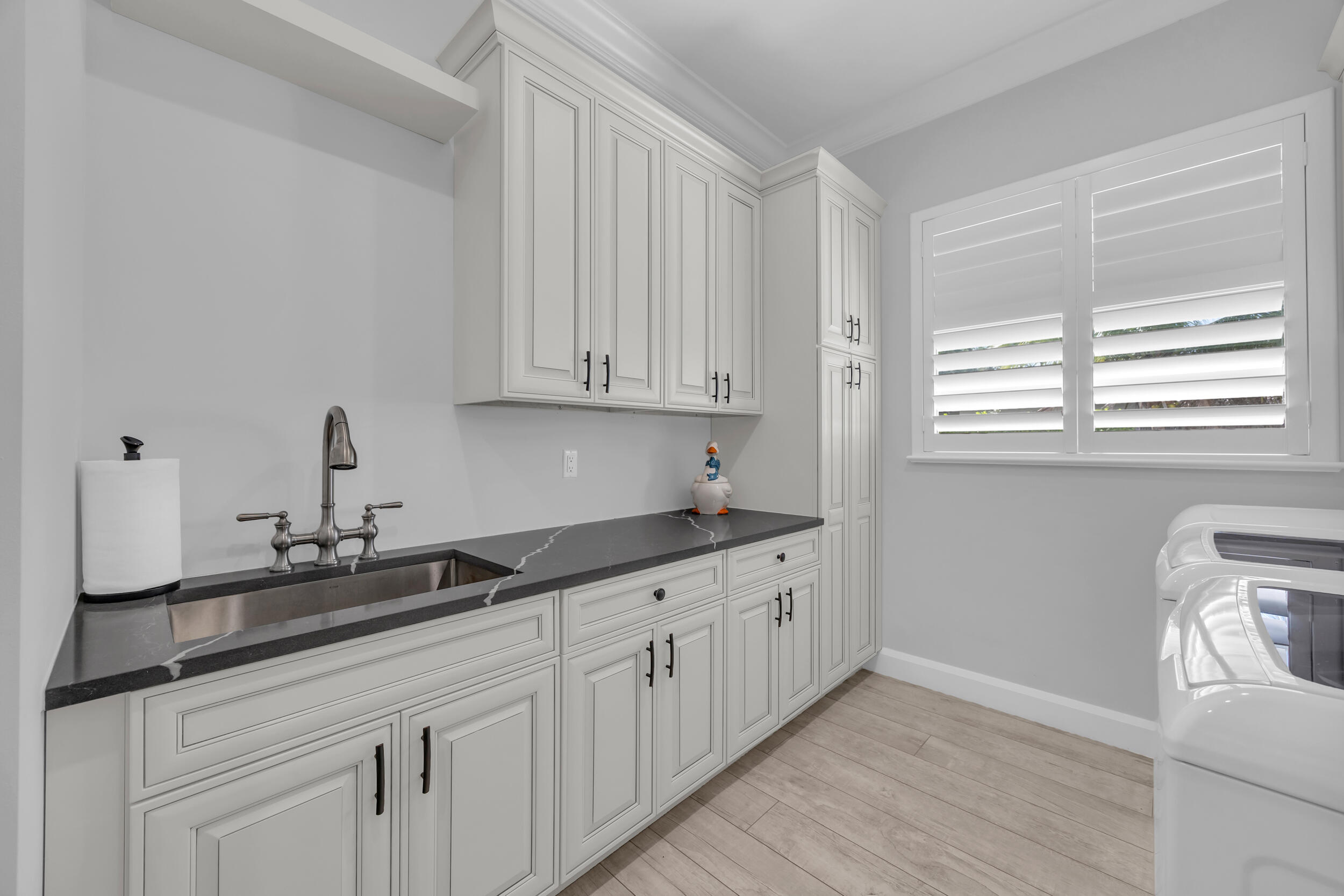 5481 Hibiscus Road Jupiter, FL 33458 - Photo 37 of 66 a kitchen with granite countertop white cabinets and sink