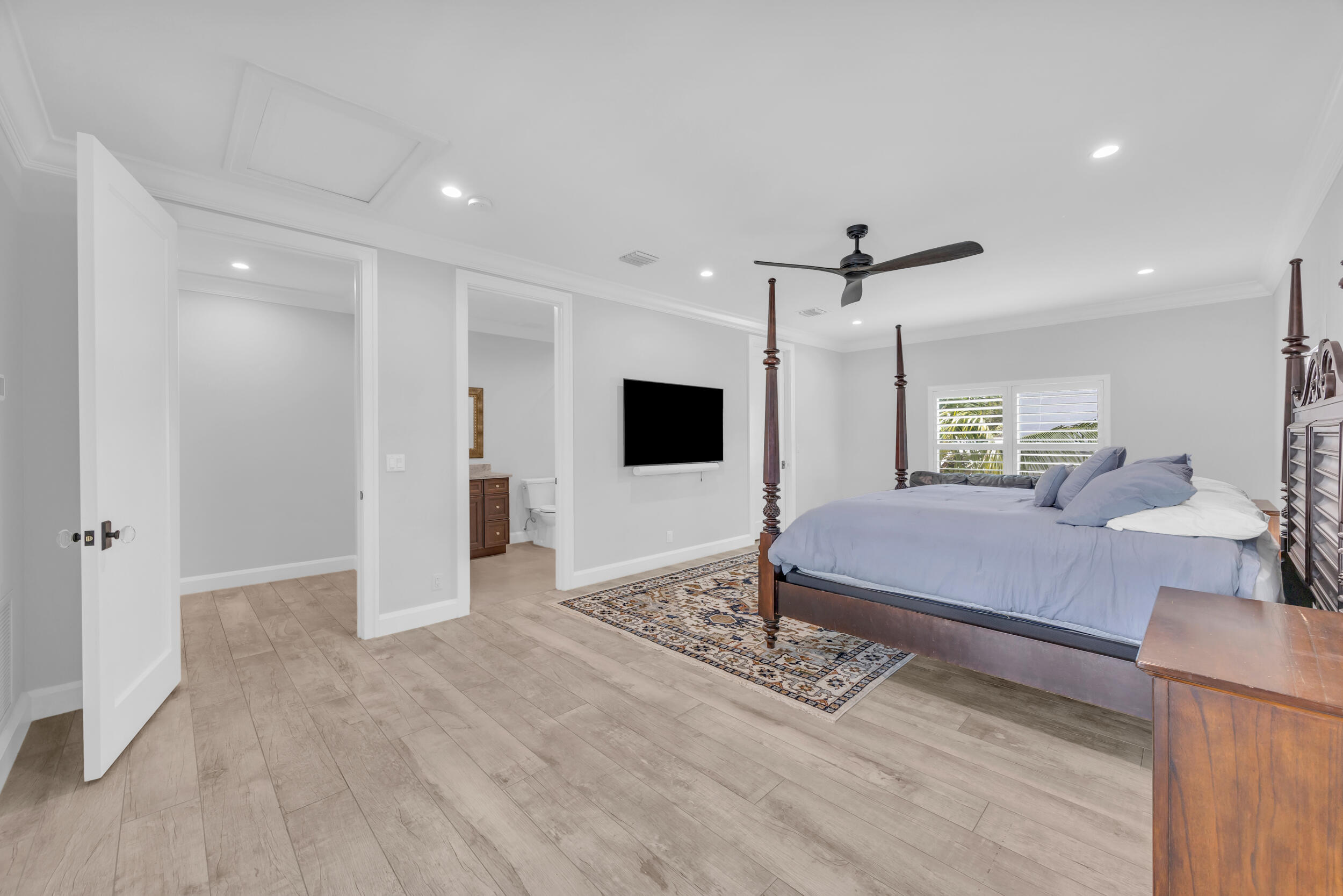 5481 Hibiscus Road Jupiter, FL 33458 - Photo 40 of 66 a spacious bedroom with a bed and a flat screen tv