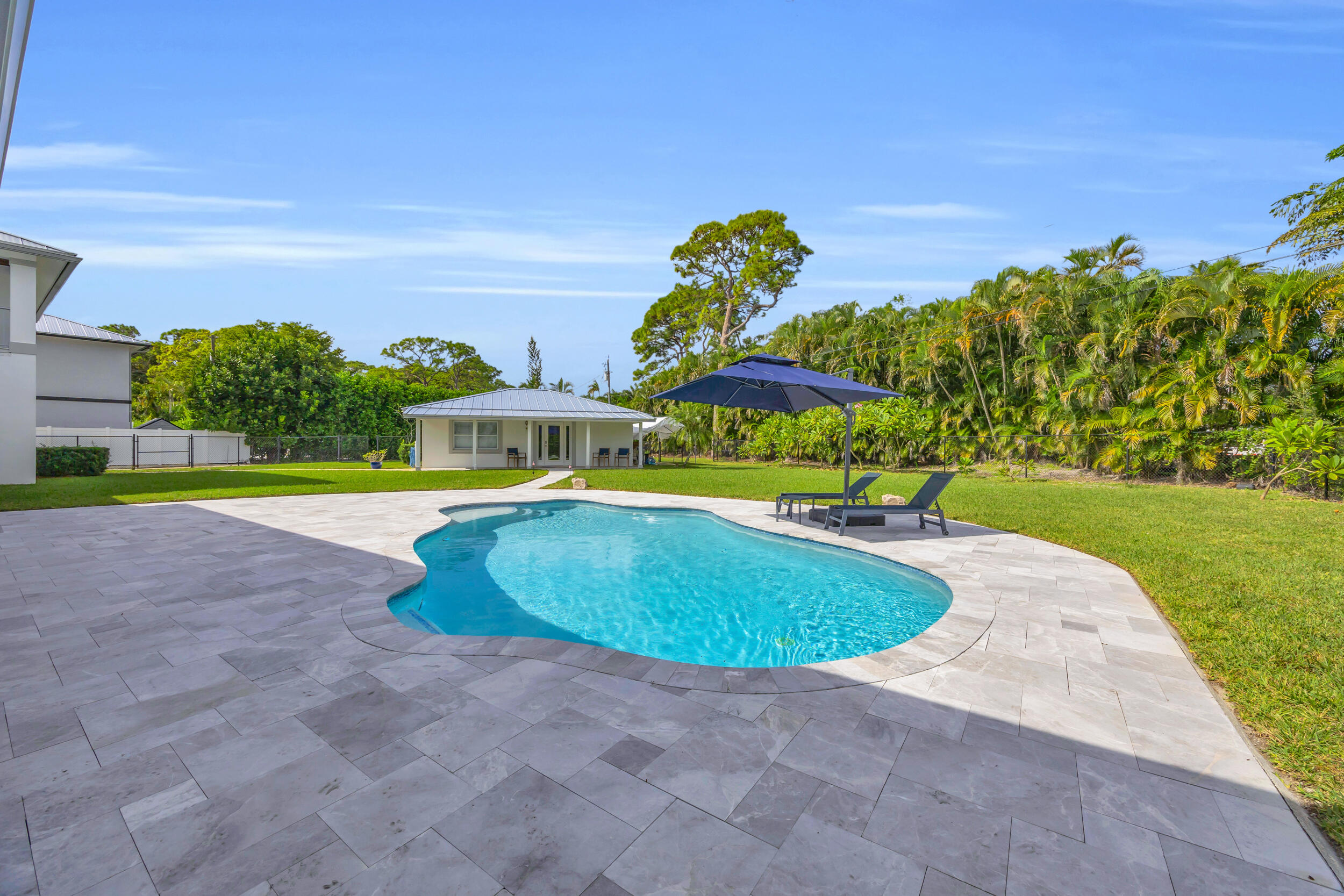5481 Hibiscus Road Jupiter, FL 33458 - Photo 51 of 66 a swimming pool with outdoor seating and garden