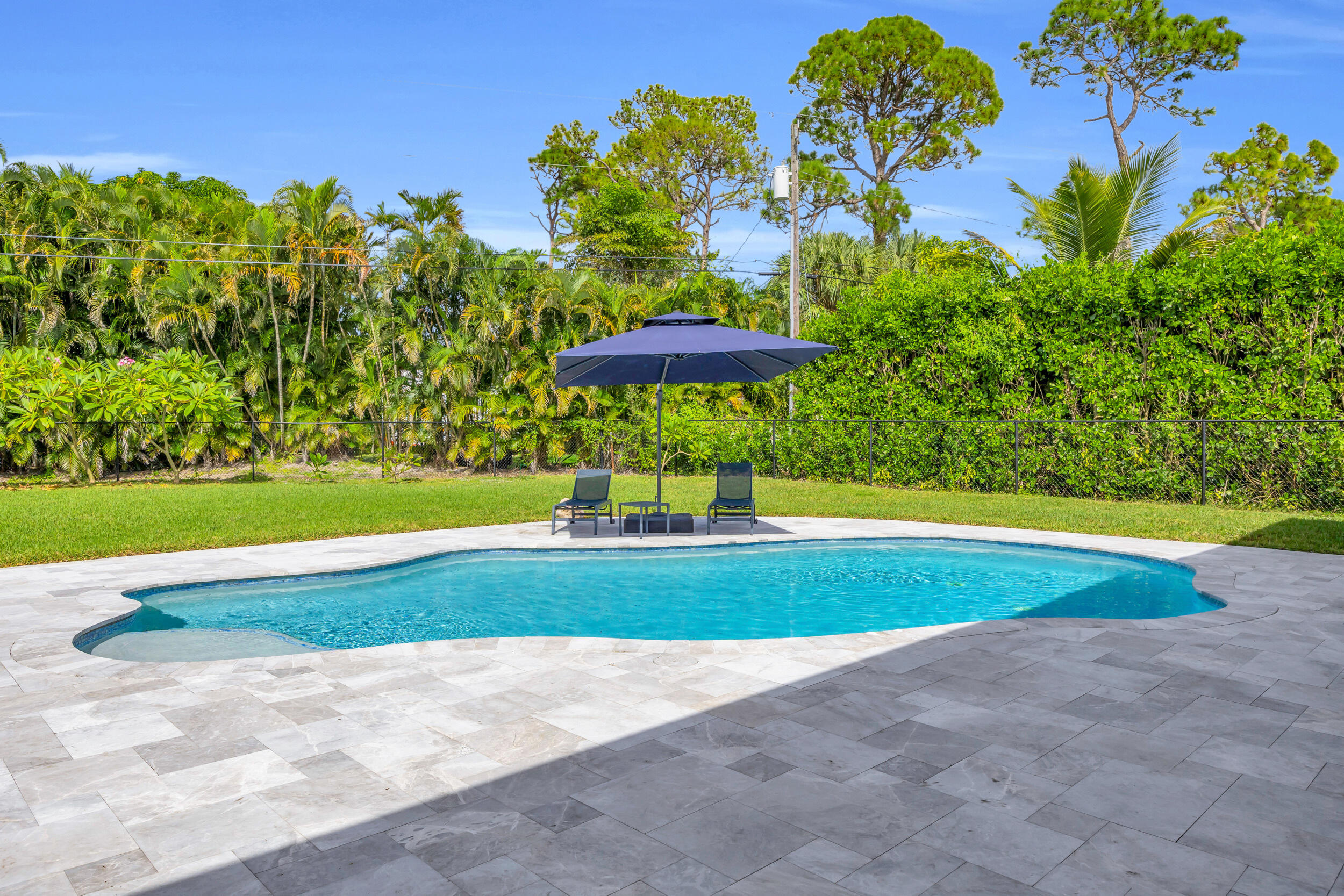 5481 Hibiscus Road Jupiter, FL 33458 - Photo 52 of 66 a view of a swimming pool with an outdoor space and seating area
