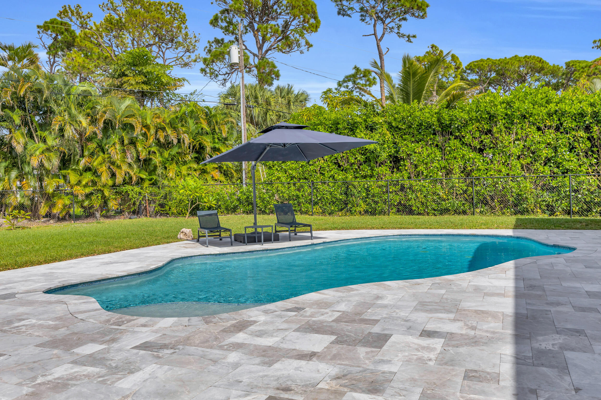 5481 Hibiscus Road Jupiter, FL 33458 - Photo 53 of 66 a view of a swimming pool with an outdoor space and seating area