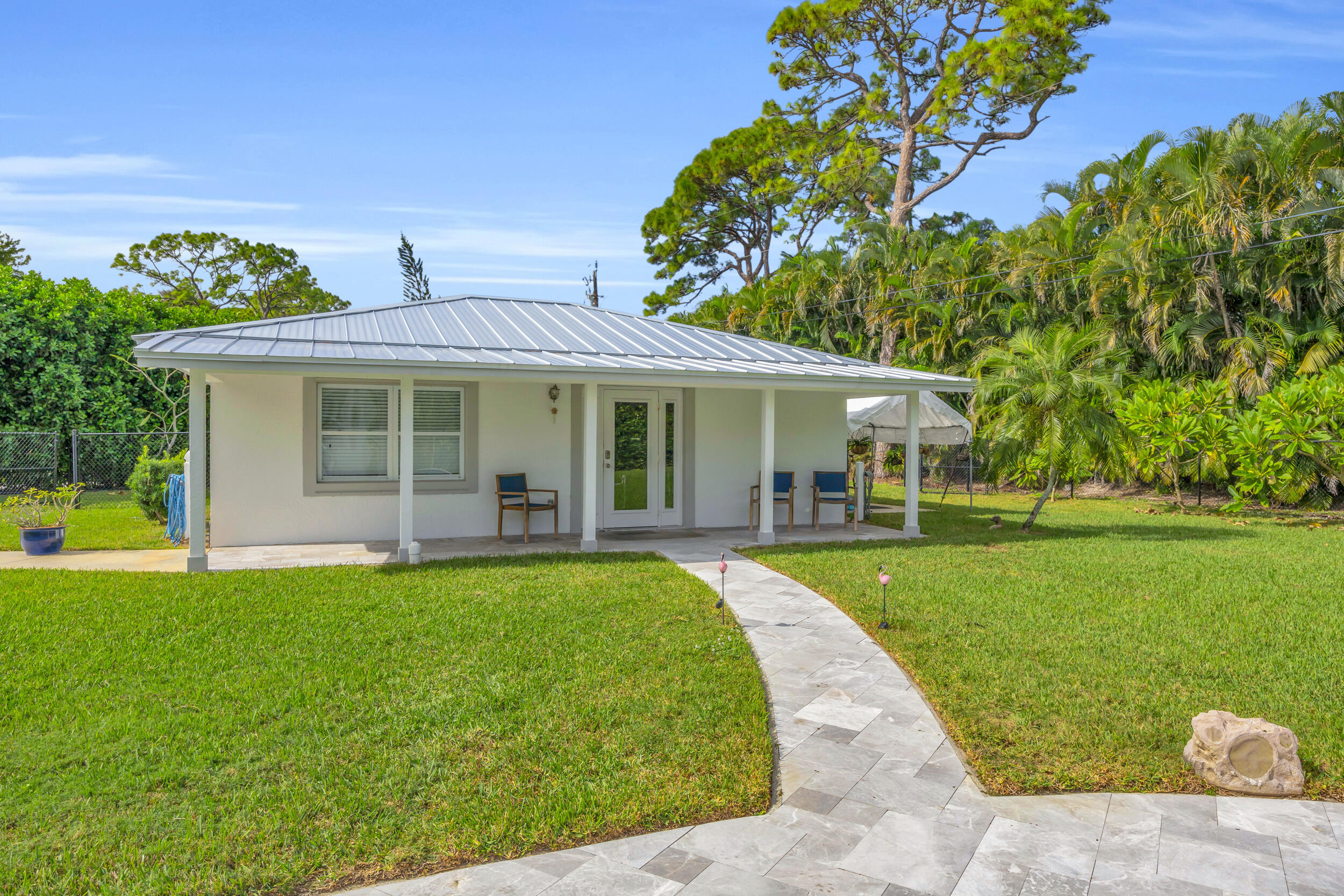 5481 Hibiscus Road Jupiter, FL 33458 - Photo 55 of 66 a front view of a house with a garden