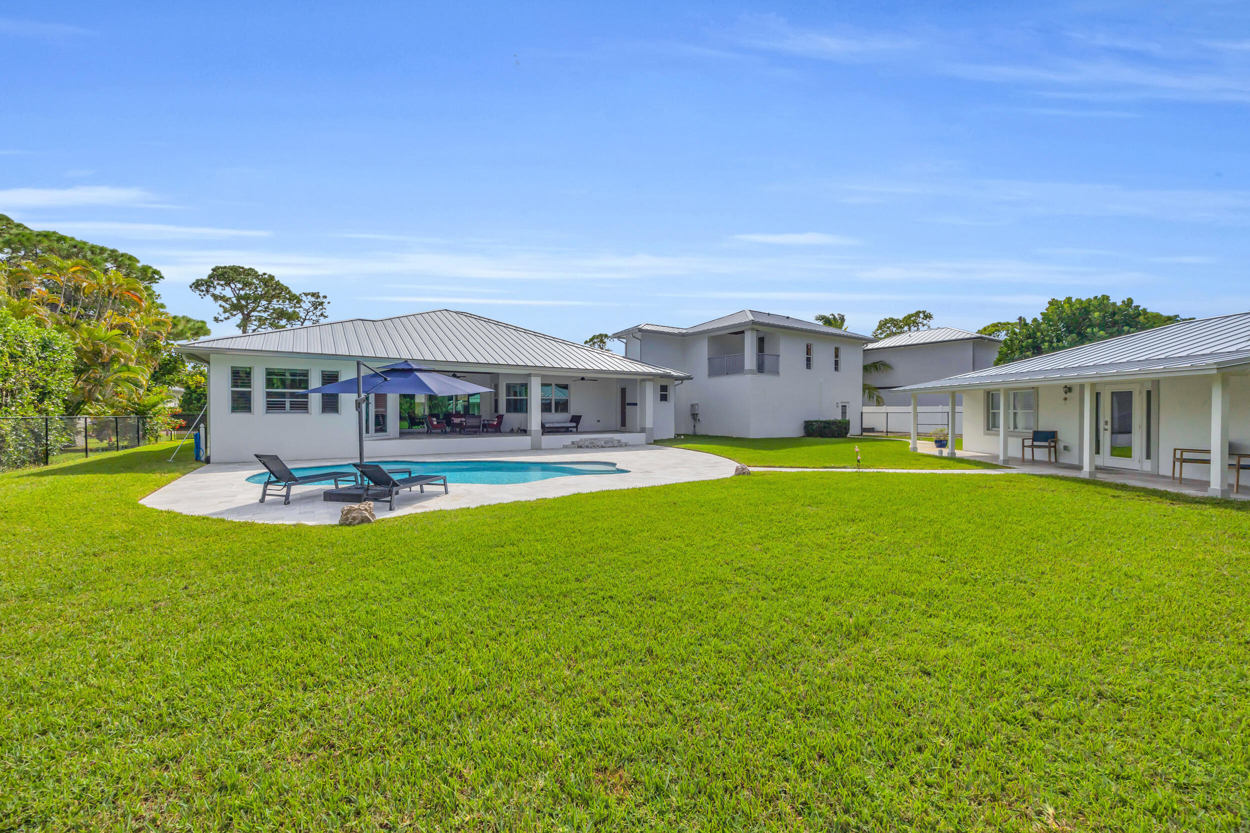 5481 Hibiscus Road Jupiter, FL 33458 - Photo 56 of 66 a view of a house with a big yard and large trees