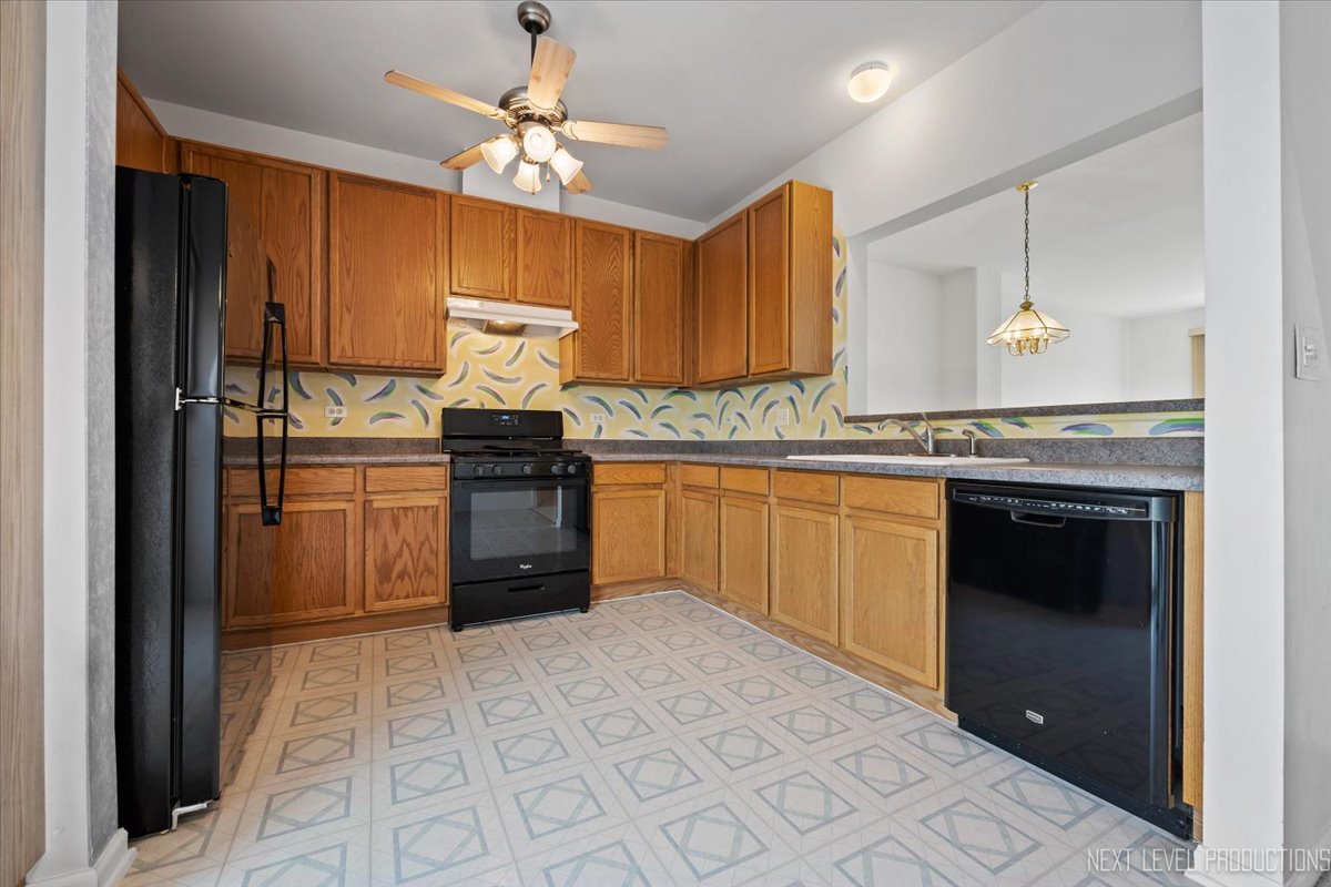 3382 Ravinia Circle, Unit 3382 Aurora, IL 60504 - Photo 12 of 33 a kitchen with stainless steel appliances granite countertop a stove sink and cabinets