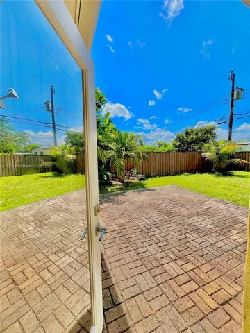 a view of a house with a yard and potted plants