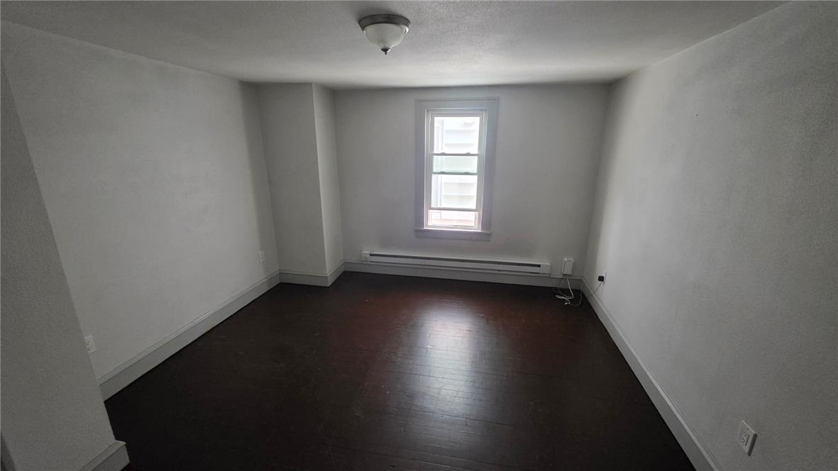 233 East Ridge Street Lansford, PA 18232 - Photo 6 of 10 Rich hardwood flooring grounds this versatile room, illuminated by a single window and overhead fixture.