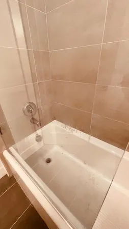 a bathroom with a bathtub sink and mirror