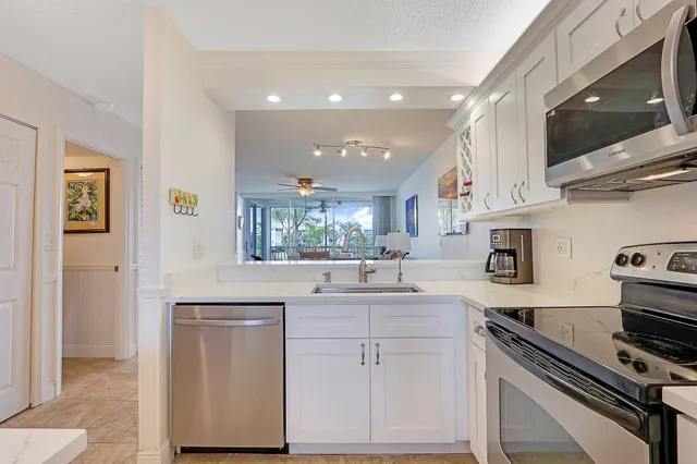 a kitchen with stainless steel appliances a sink stove and cabinets