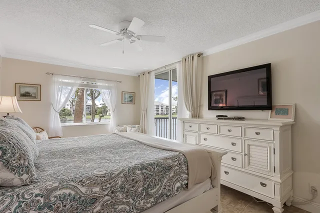 a bedroom with a large bed and a flat tv screen on dresser