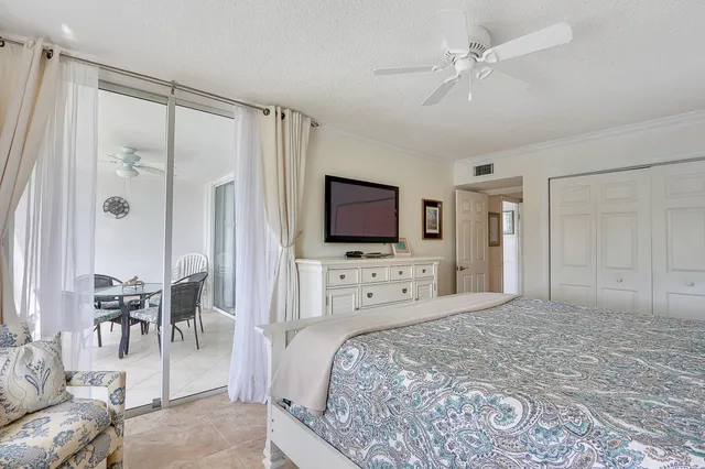 a spacious bedroom with a bed and a flat screen tv