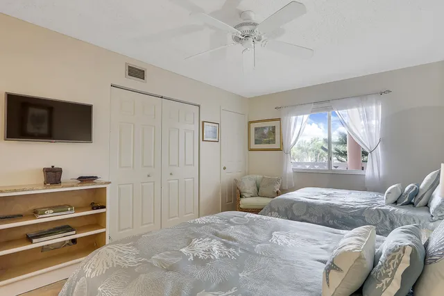 a bedroom with a bed and a flat tv screen on dresser