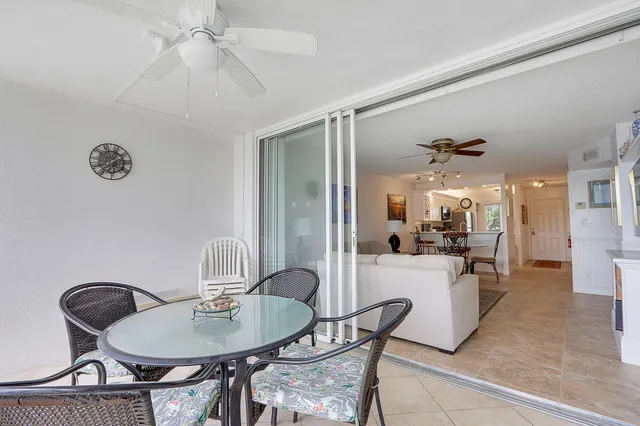 a view of a dining room with furniture and a chandelier fan
