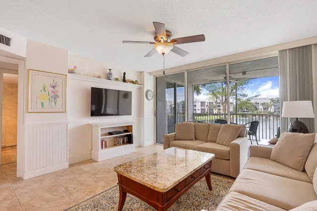 a living room with furniture a flat screen tv and a table