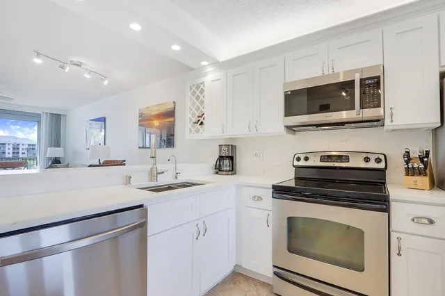 a kitchen with cabinets stainless steel appliances and a sink