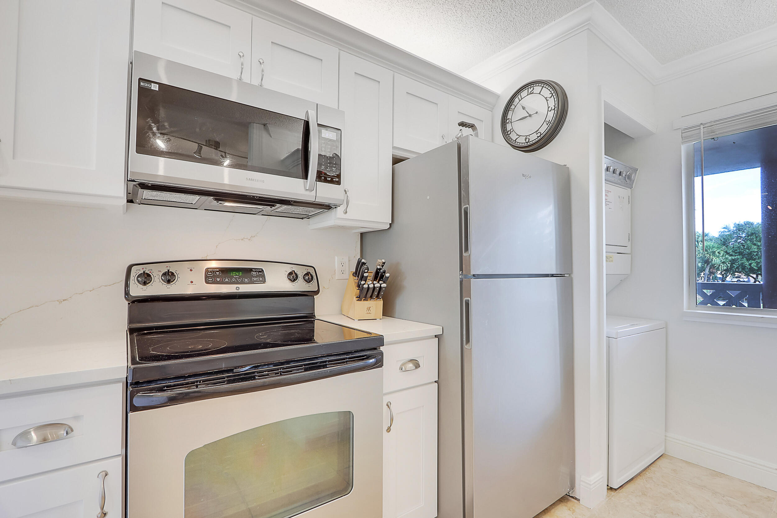 353 Highway 1, Unit A207 Jupiter, FL 33477 - Photo 10 of 28 a kitchen with stainless steel appliances granite countertop a refrigerator stove and microwave