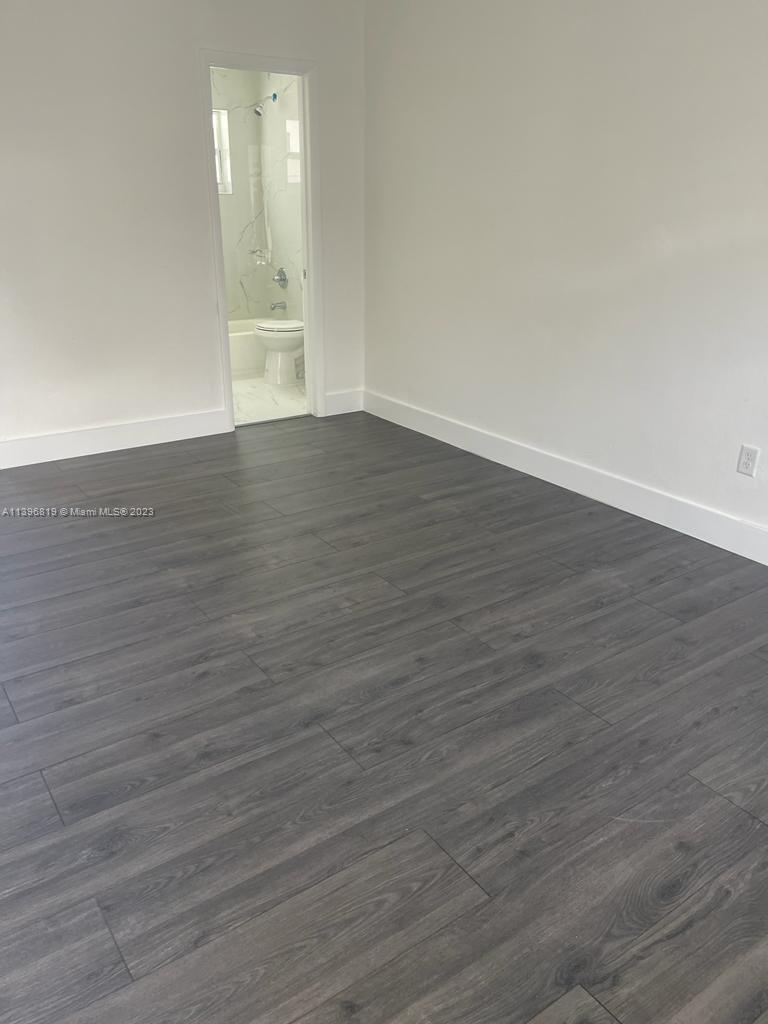 Allapattah Miami, FL 33142 - Photo 2 of 3 a view of an empty room with wooden floor and a window