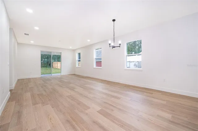 an empty room with a window and a ceiling fan
