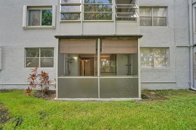 a view of a backyard with table and chairs and a large window