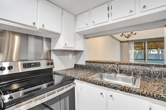 a kitchen with granite countertop a sink stainless steel appliances and cabinets