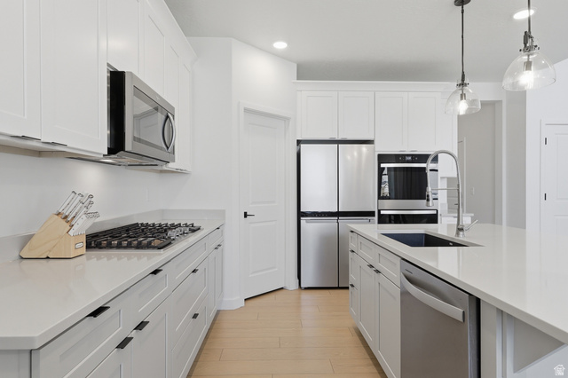 3364 Mapleton Hts Drive, Unit 101 Mapleton, UT 84664 - Photo 10 of 37 Bright kitchen featuring white shaker cabinetry, stainless steel appliances, a gas cooktop, light-toned countertops, and wood-finish flooring