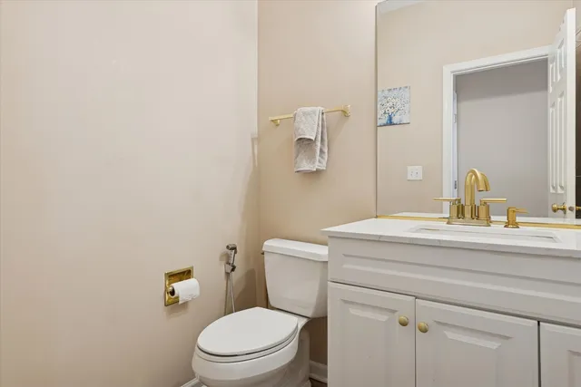 a bathroom with a granite countertop toilet sink and mirror
