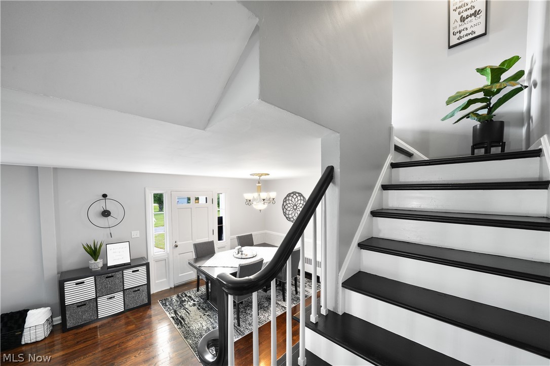2069 State Road Northwest Warren, OH 44481 - Photo 12 of 45 Stairs with dark hardwood / wood-style flooring and a chandelier