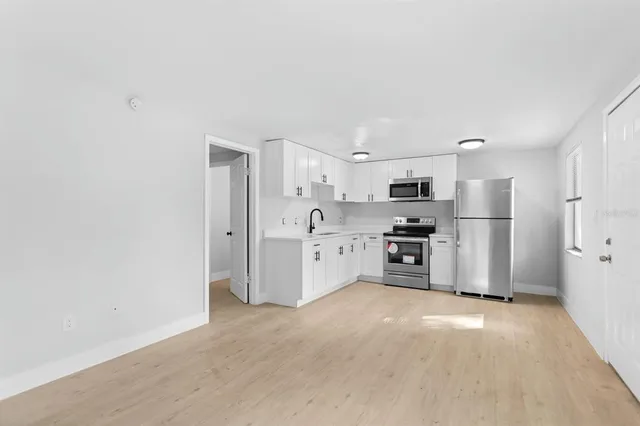 a kitchen with stainless steel appliances a refrigerator and a stove top oven