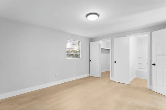 an empty room with windows and closet