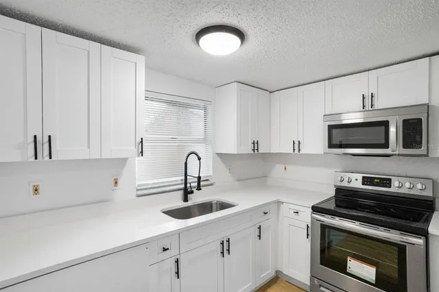 a kitchen with appliances a sink and cabinets