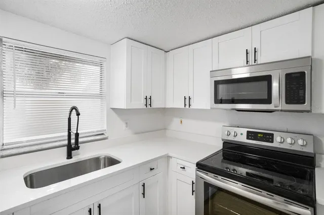 a kitchen with a sink and a stove top oven