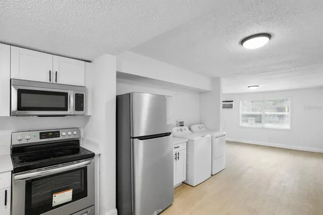 a kitchen with stainless steel appliances a refrigerator stove and microwave