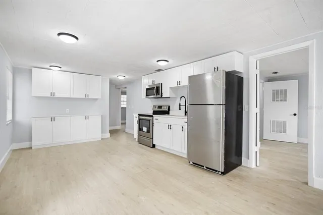 a kitchen with a refrigerator a sink and cabinets