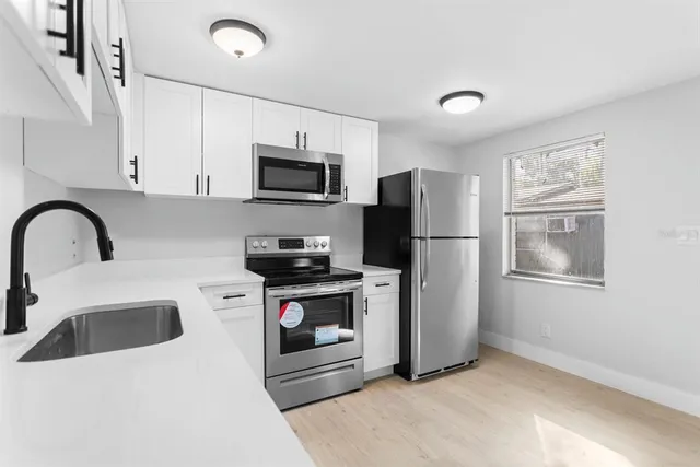 a kitchen with stainless steel appliances a refrigerator sink and microwave