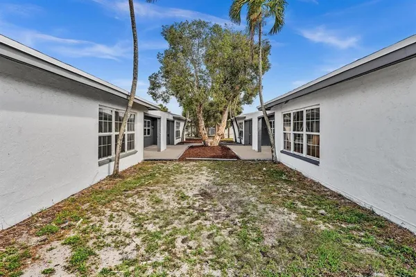 a vase of flowers sitting on a floor next to a blue wall