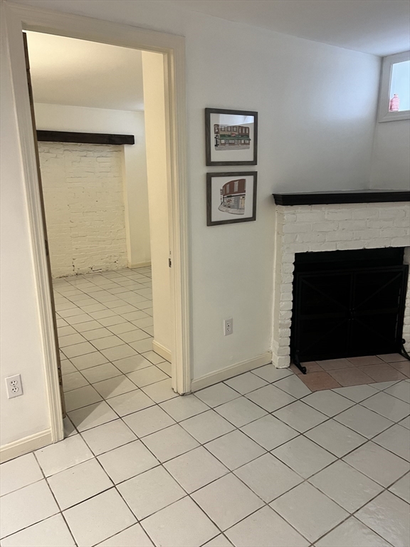 69 North Margin Street, Unit B Boston, MA 02113 - Photo 2 of 15 an empty room with wooden floor and a fireplace