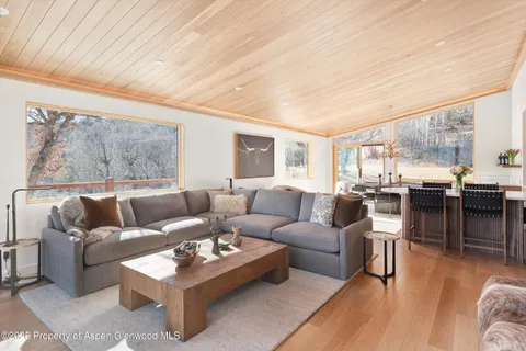 a living room with furniture a large window and a table