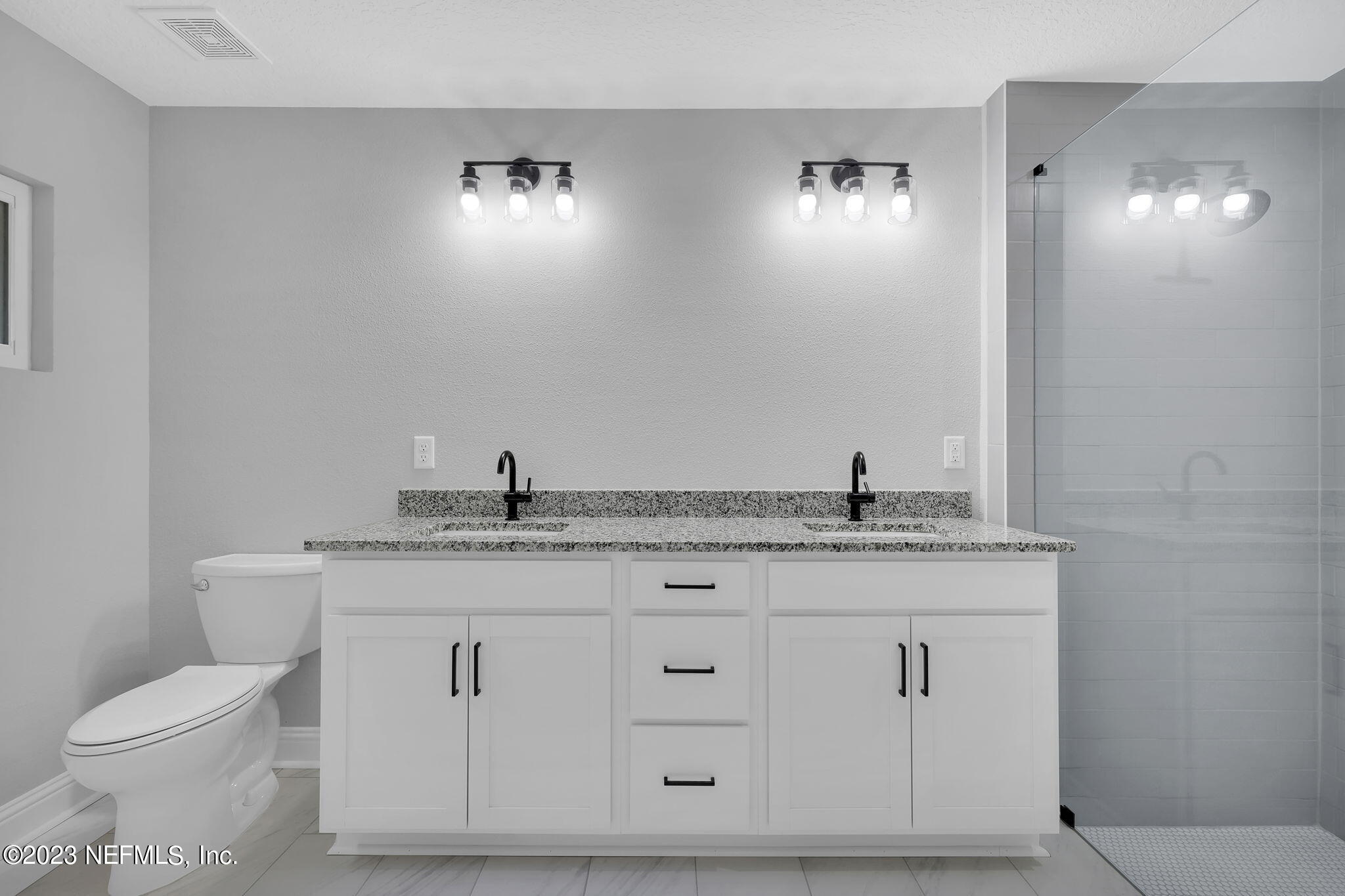 13216 Yellow Bluff Road Jacksonville, FL 32226 - Photo 22 of 28 a bathroom with a granite countertop sink a toilet and mirror