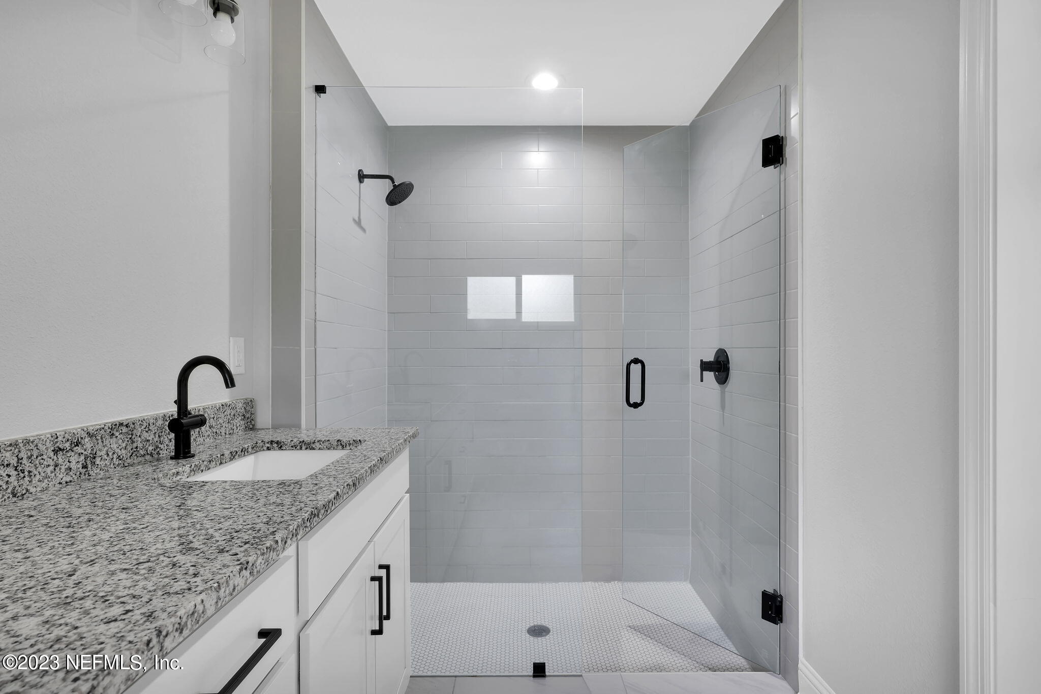 13216 Yellow Bluff Road Jacksonville, FL 32226 - Photo 23 of 28 a bathroom with a granite countertop sink a mirror and shower