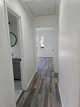 a view of a room with wooden floor and a hallway