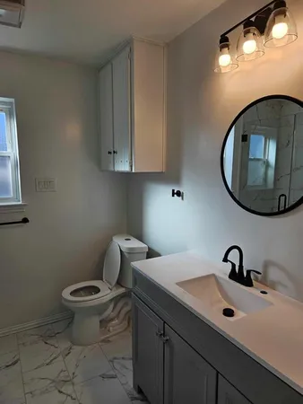 a bathroom with a toilet a sink and mirror