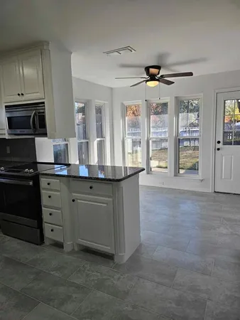 a kitchen with granite countertop a sink and cabinets
