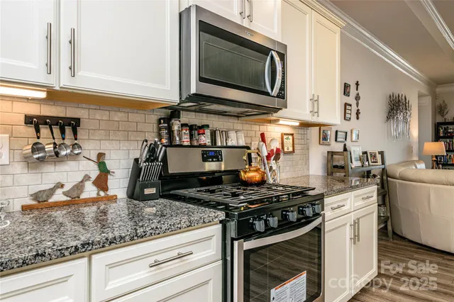 a kitchen with stainless steel appliances granite countertop a stove and a microwave