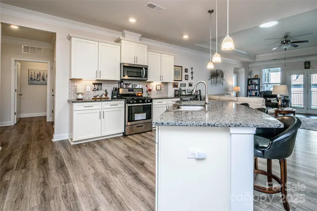a kitchen with granite countertop a sink cabinets and wooden floor